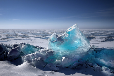 An ice cap with the frosted ocean the background